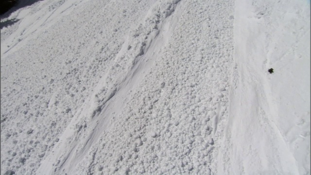 雪崩顺着陡峭的山腰峡谷而下。视频素材