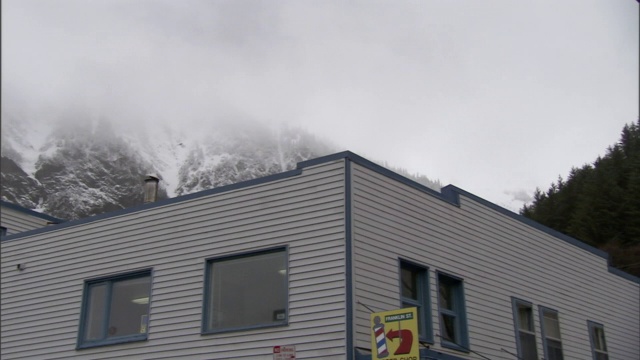 浓雾笼罩着雪山，城市上空若隐若现。视频素材