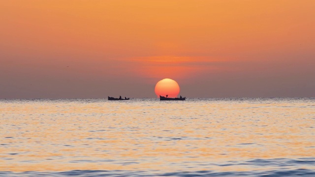 美丽的早晨，渔船和渔夫在海上。金色的海上日出。视频素材