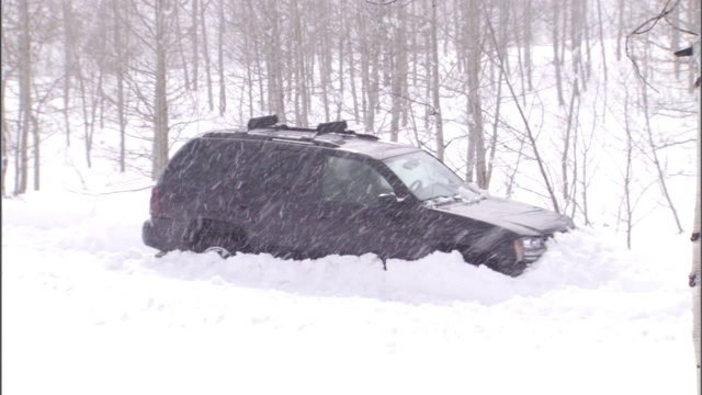 一场暴风雪把一辆SUV困在了雪堆里。视频素材