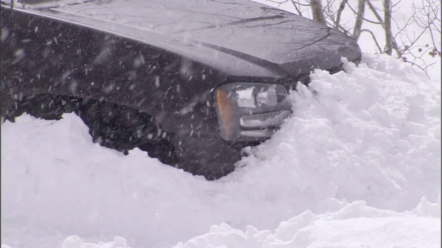 一场暴风雪把一辆SUV困在了雪堆里。视频素材