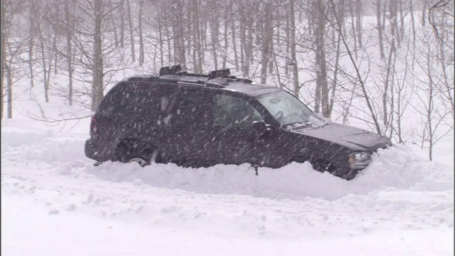 一场暴风雪把一辆SUV困在了雪堆里。视频素材