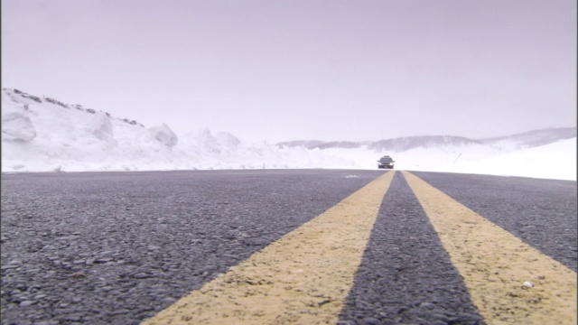 一辆汽车在下雪的路上行驶。视频素材