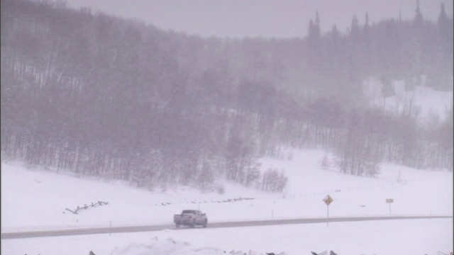 一辆大卡车在积雪的路上行驶。视频素材