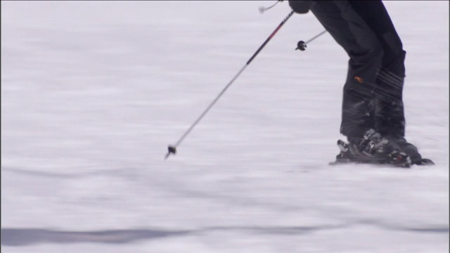 滑雪者沿着多雪的斜坡弯弯曲曲地滑下。视频素材