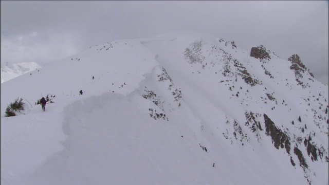 救援人员站在白雪覆盖的山顶上。视频素材