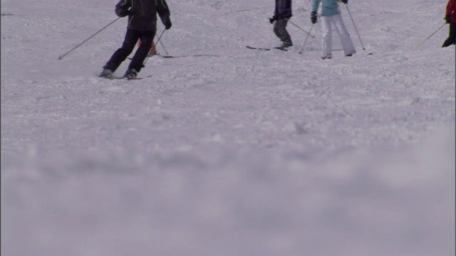 滑雪者从多雪的山坡上滑下来。视频素材