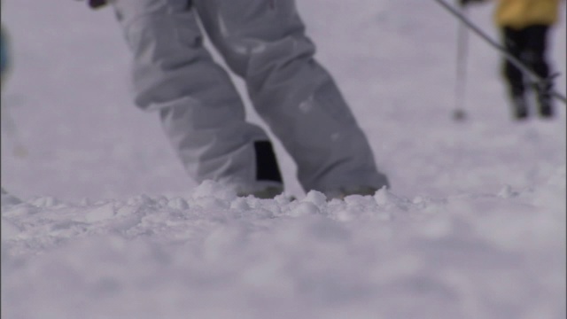 滑雪者从多雪的山坡上滑下来。视频素材