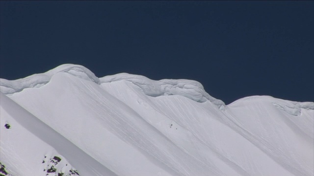 爆炸在多雪的山坡上引发了雪崩。视频素材