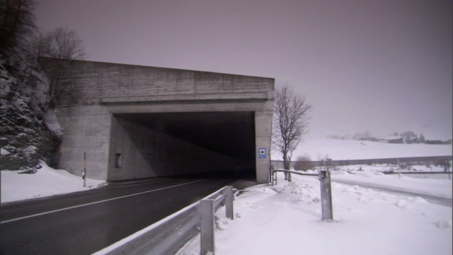 汽车穿过雪地附近的隧道。视频素材