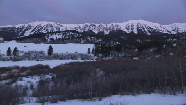 大雪覆盖了山脉下森林覆盖的山谷。视频素材