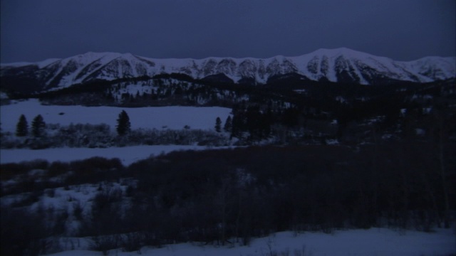 大雪覆盖了山脉下森林覆盖的山谷。视频素材