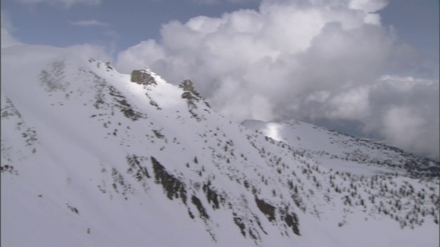 巨大的云层盘旋在雪山之上。视频素材