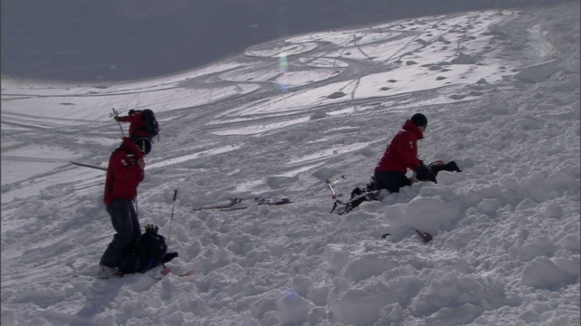 事故模拟小组的成员正在将一个人体模型从雪崩路径上移除。视频素材