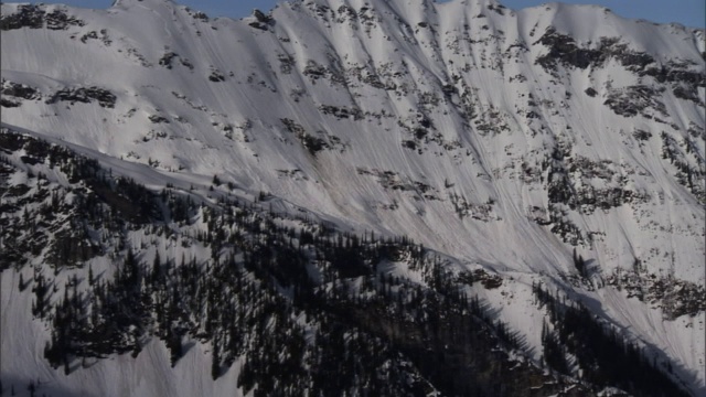 一架直升机在雪山附近飞行。视频素材