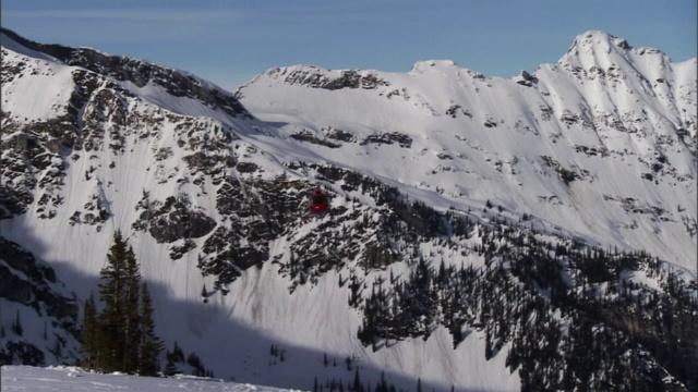 一架直升机在雪山附近飞行。视频素材