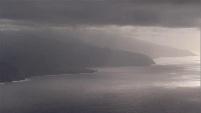 巨大的风暴云层聚集在多山的海岸上。视频素材