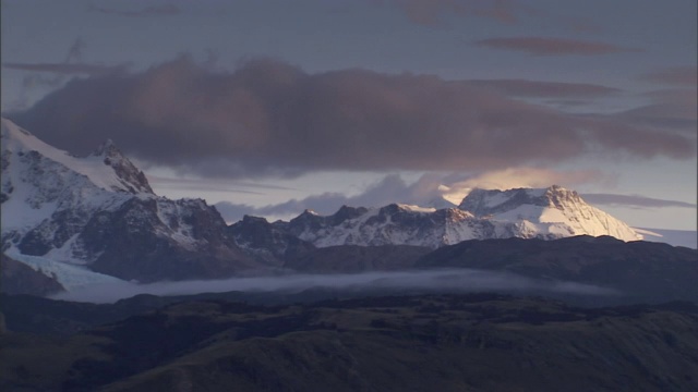 乌云在白雪覆盖的山峰上飘过。视频素材