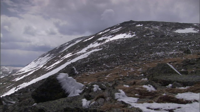 雪紧贴着岩石和陡峭的山坡。视频素材