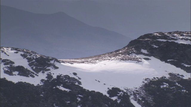 阳光照射在白雪覆盖的山峰上。视频素材