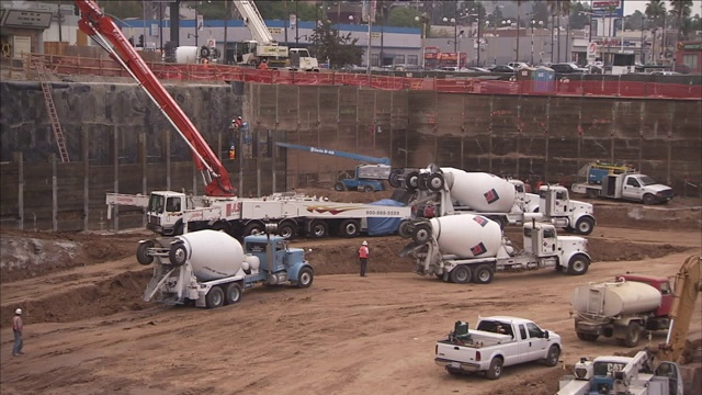 水泥车和起重机在建筑工地操作。视频素材