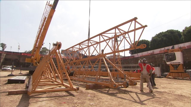 建筑工人在建筑工地提升和移动设备。视频素材