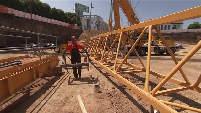 建筑工人在建筑工地搬运设备。视频素材