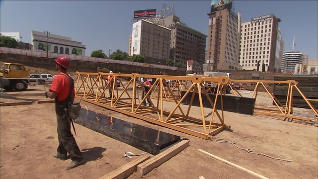 建筑工人在建筑工地周围磨工。视频素材