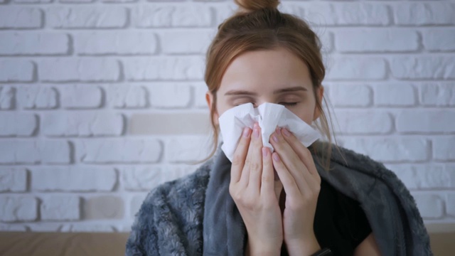 肖像年轻漂亮的女人朝餐巾纸咳嗽寒冷的秋天流感季节疾病发烧流行性感冒健康疾病感染流感偏头痛病。关闭了。视频素材