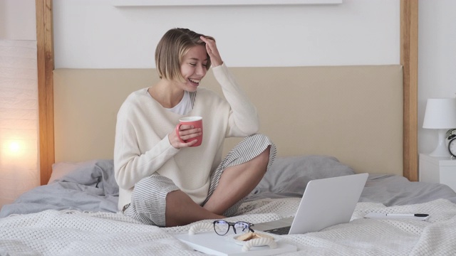 快乐的女人在床上用笔记本电脑打视频电话视频素材