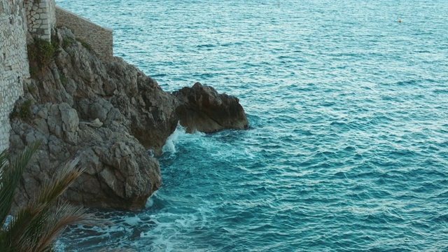 海浪打破海滩岩石景观。视频下载