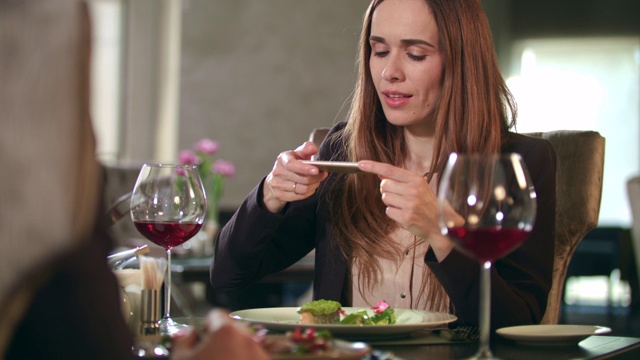 女商人在餐厅用智能手机拍美食照视频素材