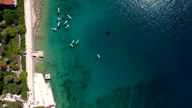 人们在海边码头附近皮划艇的鸟瞰图，马里Lošinj，克罗地亚。视频素材