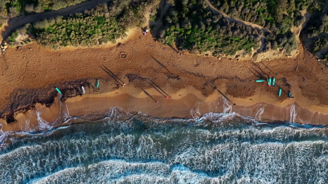 Ghajn Tuffieha海滩鸟瞰图。冲浪者。日落，青山绿水，沙滩，海浪在海里。冬天。镜头移到右边。马耳他视频素材