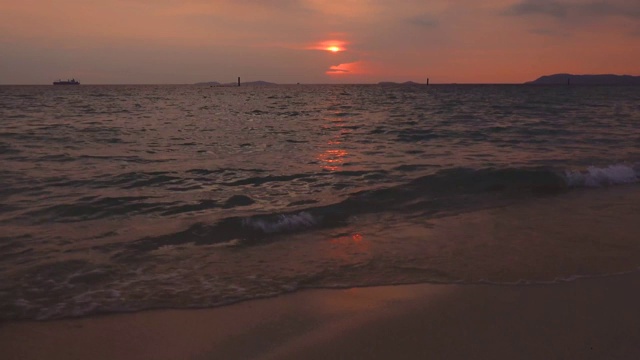 美丽的夕阳景观在海上和橙色的天空与可怕的太阳反射在平静的波浪作为背景。海滩上令人惊叹的夏日日落景色。视频素材