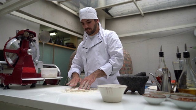 餐馆里，男厨师正在揉面准备披萨视频素材