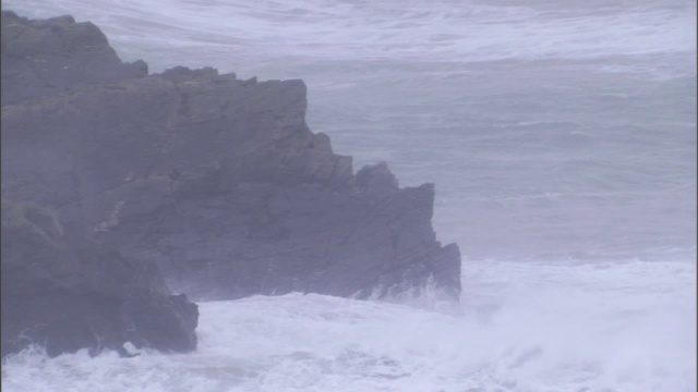 暴风雨的波浪拍打着海岸上的巨石和悬崖峭壁。视频素材