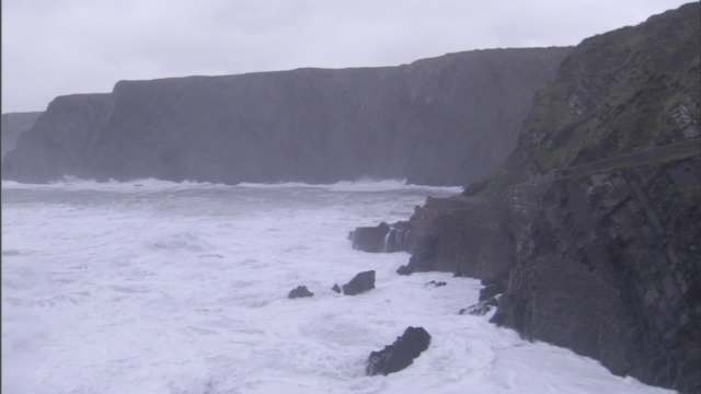 汹涌的海浪拍打着布满岩石的海岸线。视频素材