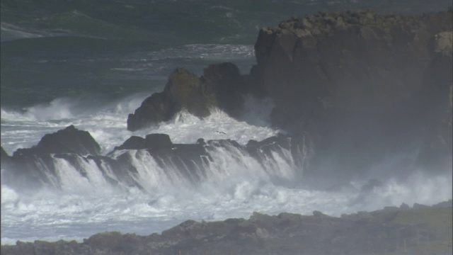 海浪冲击着布满岩石的浅滩。视频素材