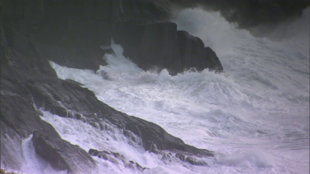 暴风雨时波浪冲击着多岩石的海岸。视频素材