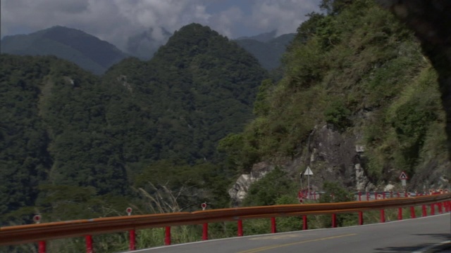 一条狭窄的道路蜿蜒穿过山区的岩层。视频素材