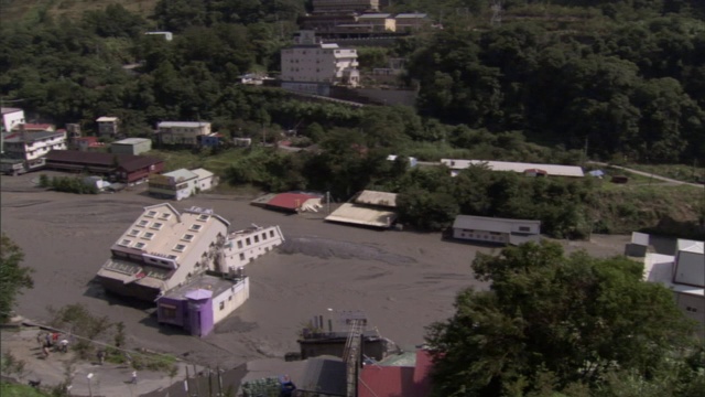 飓风过后，一幢被掀翻的建筑躺在泥泞的街道上。视频素材