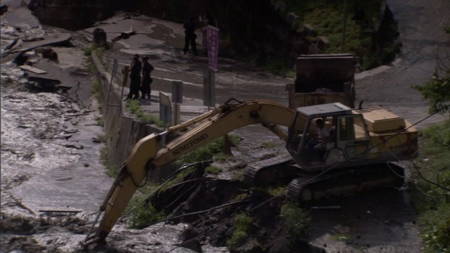 一台挖土机从泛滥的河流中捡拾泥土和瓦砾。视频素材