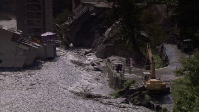 泛滥的河水汹涌而过损坏的道路和桥梁。视频素材