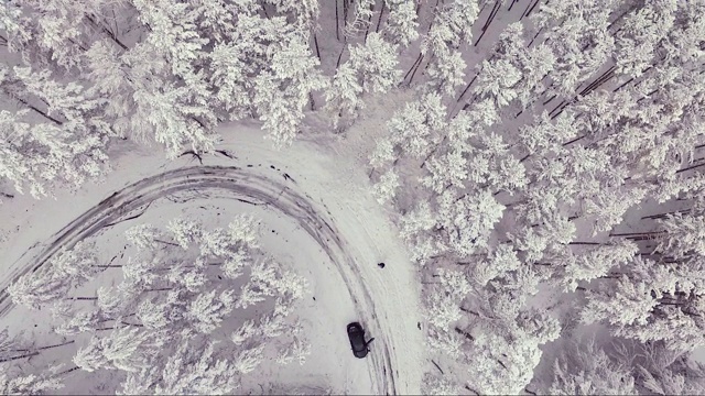 在冬季的暴风雪中，汽车停在了弯道上。鸟瞰图。视频素材