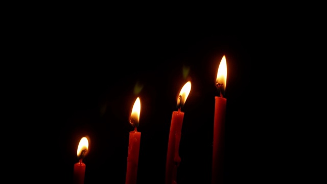 夜晚点燃的烛光。黑色背景上燃烧的蜡烛。抽象背景的概念。视频素材