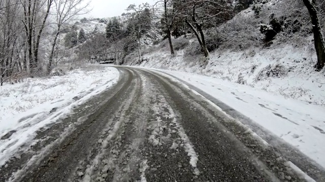 在有很多雪的冰冻道路上开得很慢视频素材