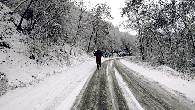 初雪后的冬日，年轻人、成年人独自在公园或森林小径上慢跑视频素材