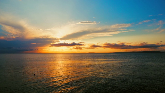 在一个愉快的夏天晚上的海景:美丽的日落，彩色的云，一个纯海与游艇，在水面上闪烁的太阳。海洋，海洋，自然视频旅游，度假和冥想的地点视频素材