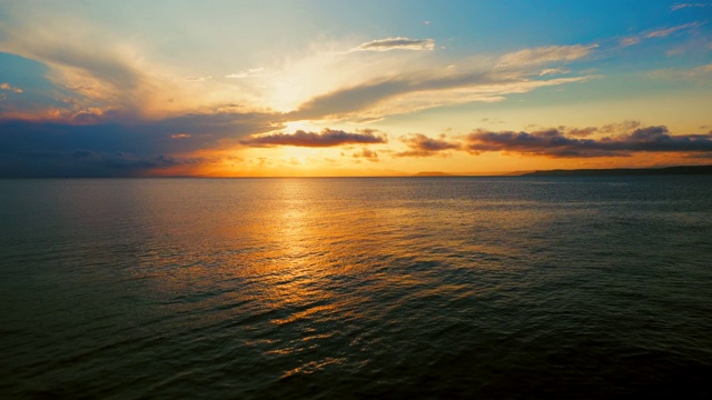 在一个愉快的夏天晚上的海景:美丽的日落，彩色的云，一个纯海与游艇，在水面上闪烁的太阳。海洋，海洋，自然视频旅游，度假和冥想的地点视频素材